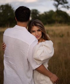 a man and woman embracing in a field