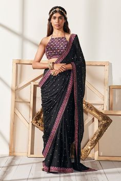 Black georgette  saree with sequins embellishments with an embroidered border. Paired with thread work embellished backless padded blouse.
Components:2
Pattern:Embroidered
Type of Work:Floral Pattern
Neckline:Halter Neck
Sleeve Type:Sleeveless
Fabric:Saree: Georgette, Blouse: Silk
Color:Black
Other Details:
Cotton lined blouse
Back criss-cross tassel tie-up
Occasion:Reception - Aza Fashions Black Georgette Saree, Embellished Saree, Backless Blouse, Ready To Wear Saree, Georgette Blouse, Black Saree, Embroidered Border, Embellished Blouse, 12 Weeks