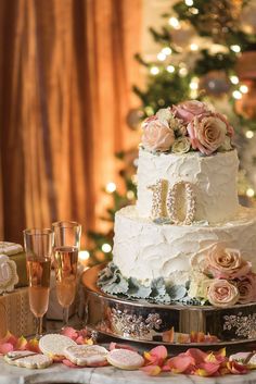 a white wedding cake sitting on top of a table next to champagne glasses and cookies