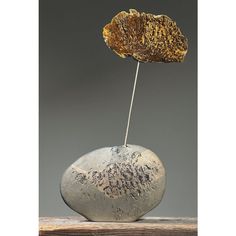 a rock with a stick sticking out of it sitting on top of a wooden table