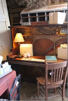 an old wooden desk with a lamp on it