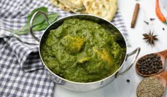 a metal pot filled with green sauce next to spices