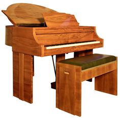 a wooden piano sitting next to a bench with a stool on it's side