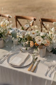 the table is set with flowers and silverware