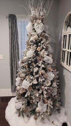 a white christmas tree with silver and gold ornaments