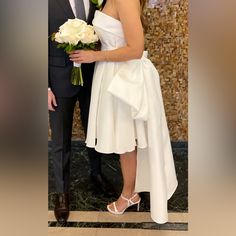 a man in a suit and tie standing next to a woman in a white dress