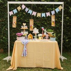 a table topped with cake and desserts on top of a grass covered field