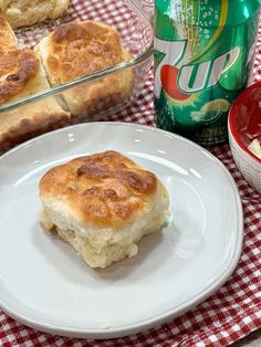 a plate with some biscuits on it next to a can of soda and a glass dish