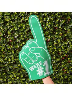 a person holding up a green peace sign in front of some bushes with the words we are 1 on it