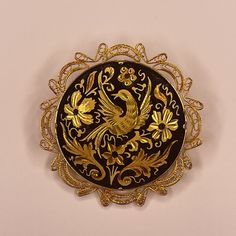 This beautiful vintage Spanish Damascene brooch showcases a delicate dove and floral design set against a striking black background, framed in an elegant gold-tone setting. The craftsmanship of Damascene jewelry, known for its intricate inlay work, shines through in this exquisite piece. Measuring 2 inches, the brooch combines timeless artistry with a rich history of Spanish jewelry-making. While the brooch shows some light wear consistent with its age, it remains a stunning piece that captures the elegance and detail of traditional Damascene techniques. The minor wear adds character, giving it a true vintage charm that will appeal to collectors and lovers of unique jewelry. Whether worn as a statement accessory or added to a jewelry collection, this brooch is perfect for those who appreci Damascene Jewelry, Spanish Jewelry, Design Set, True Vintage, Tucson, Vintage Charms, Black Background, Black Backgrounds, Jewelry Collection