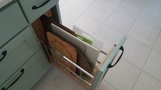 an open drawer in a kitchen with utensils and cutting boards inside the cabinet