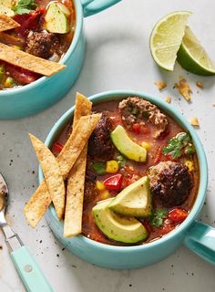 two bowls filled with meat and vegetables next to tortilla chips on a table