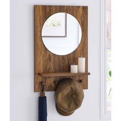 a wooden shelf with a mirror and hat on it