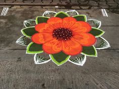 an orange flower painted on the ground with green leaves and white lines in the middle