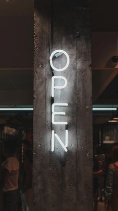 a neon sign that reads open on the side of a building