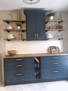 a kitchen with blue cabinets and open shelves