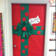 the door is decorated with green and red polka dot ribbon, which has a bow on it