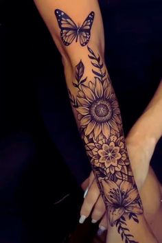 a woman's arm with sunflowers and butterflies on it