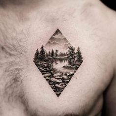 a man's chest with a landscape tattoo on it