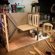 a doll house made out of cardboard and wood with stairs leading up to the second floor