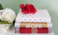 three books stacked on top of each other with the word hope written on them next to flowers