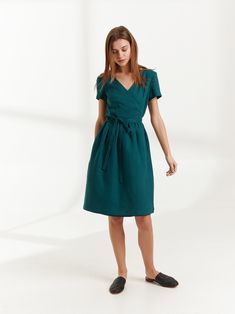 "FLORA is a true wrap linen dress with side seam pockets. DETAILS - True wrap dress - Below the knee length - Smock silhouette - Short sleeve - Side seam pockets - Oeko-Tex certified 100% midweight linen - Cut and sewn to order just for you in our studio COLOR - Emerald Blue, you can also choose other colors above - Fabric samples are available here https://www.etsy.com/listing/586569696/linen-fabric-samples SIZING & FIT - Fits true to size - Model is wearing a size XS - Model is 5'8.9\" / 1 V-neck Linen Dress For Workwear With Relaxed Fit, Relaxed Fit Linen V-neck Dress For Work, Relaxed Fit Linen Work Dress, Knee-length Linen Dress With Tie Waist, Fitted Linen V-neck Dress For Work, Fitted Knee-length Linen Dress With Pockets, Fitted V-neck Linen Dress For Work, Relaxed Fit V-neck Linen Dress For Work, Knee-length Belted Fitted Linen Dress