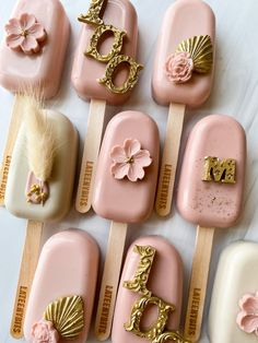 some pink and white soaps with gold designs on them