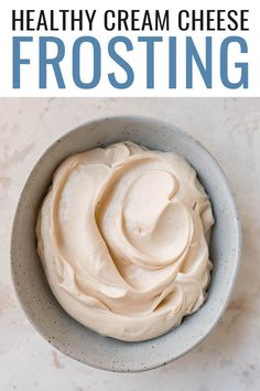 a bowl filled with cream cheese frosting on top of a table