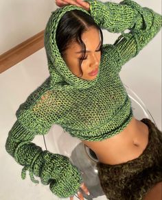 a woman wearing a green knitted hoodie and matching skirt poses for the camera