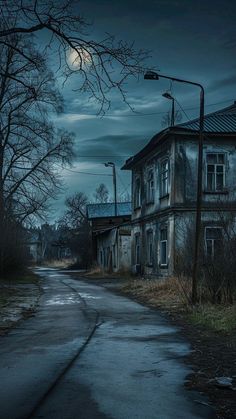 an old run down house with the moon in the sky above it and trees on either side