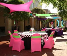 tables and chairs are set up outside for an outdoor party with checkered tablecloths