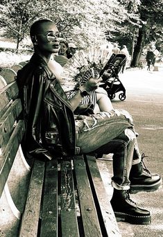 a black and white photo of a man sitting on a bench with flowers in his hand