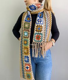 a woman is wearing a crocheted scarf with fringes and beads on it