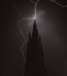 lightning strikes behind a church steeple in black and white