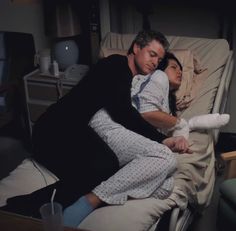 a man and woman laying in a hospital bed