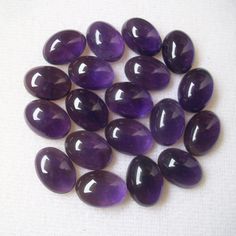 several purple stones are shown on a white surface