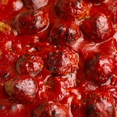 a close up view of some food with red sauce on the top and meatballs in the middle