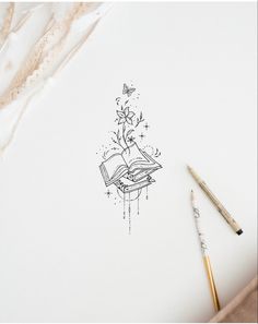 a drawing of a book with flowers and butterflies coming out of it on top of a white paper