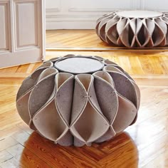 a round ottoman sitting on top of a hard wood floor