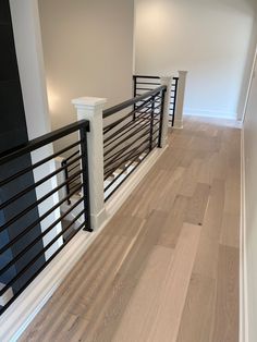 an empty room with wood floors and black railings on the side of the wall