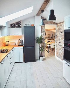 a kitchen with an oven, refrigerator and sink in it's center island next to a brick wall