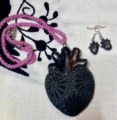 We're thrilled to introduce our latest collection of handcrafted corazones from San Bartolo Coyetepec, Oaxaca! These stunning pieces feature intricate carvings and are made from burnished black clay, showcasing the traditional milagro and artery styles. Each necklace is carefully crafted with chaquira beads and measures 20" long, making it a perfect statement piece. These unique treasures are sold separately, and quantities are limited! Don't miss out on adding a touch of Oaxaca's rich culture t Handmade Heart-shaped Jewelry For Festivals, Traditional Handmade Heart-shaped Jewelry, Traditional Handmade Heart Jewelry, Traditional Heart-shaped Jewelry With Heart Beads, Artisan Jewelry With Heart Beads, Traditional Handmade Heart Necklaces, Handmade Heart-shaped Festival Jewelry, Black Hand Tooled Bohemian Jewelry, Black Hand-tooled Bohemian Jewelry