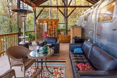 a living room with couches, chairs and a coffee table in front of an airstream