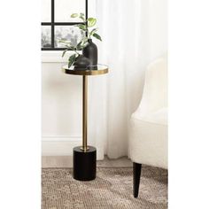 a black and gold plant stand with a potted plant on it in front of a window