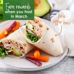 a white plate topped with a cut in half sandwich next to veggies and an avocado