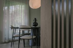 a dining room table and chairs in front of a window with blinds on the outside