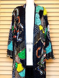 "This is a RARE and FABULOUS vintage piece embellished with bright and colorful sequins and glass beads on black silk and fully lined. There is 1 hook & eye closure at the top. It's in perfect condition! Bust - 56\" + (measured with the front brought together) Upper Arm Circumference - 29\" Top to Bottom Length - 40\" All of my items come from a smoke-free and pet-free home. If you have any questions, please don't hesitate to ask!" Multicolor Embellished Sequin Fabric For Night Out, Long Sleeve Sequined Outerwear For Festivals, Multicolor Sequined Party Outerwear, Party Multicolor Sequined Outerwear, Embellished Black Outerwear For Party Season, Black Embellished Outerwear For Party Season, Spring Embellished Multicolor Sequin Fabric, Multicolor Sequined Outerwear For Fall, Fitted Multicolor Outerwear For Festivals