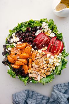 a bowl filled with salad and fruit on top of a table