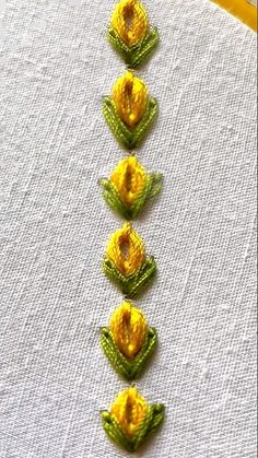 a row of yellow flowers sitting on top of a white cloth