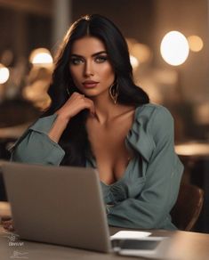 a woman sitting at a table with a laptop in front of her and looking off to the side